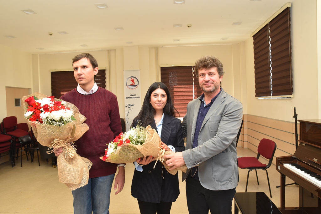Ferit Hoca, Ali Alparslan ve Berfin Özgenç'e çiçek buketi verirken çekilmiş bir kare
